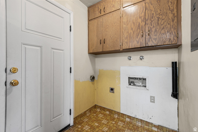 542 East 3400th Street North Provo, UT 84604 - Photo 16 of 39 Utility space featuring wood-finish cabinetry, a white paneled door with brass hardware, and patterned floor tile