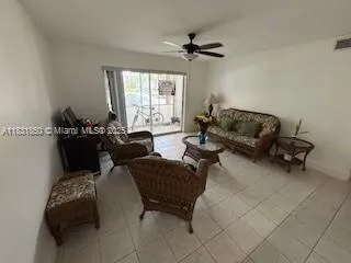 a living room with stainless steel appliances kitchen island granite countertop a sink counter space and view of living room