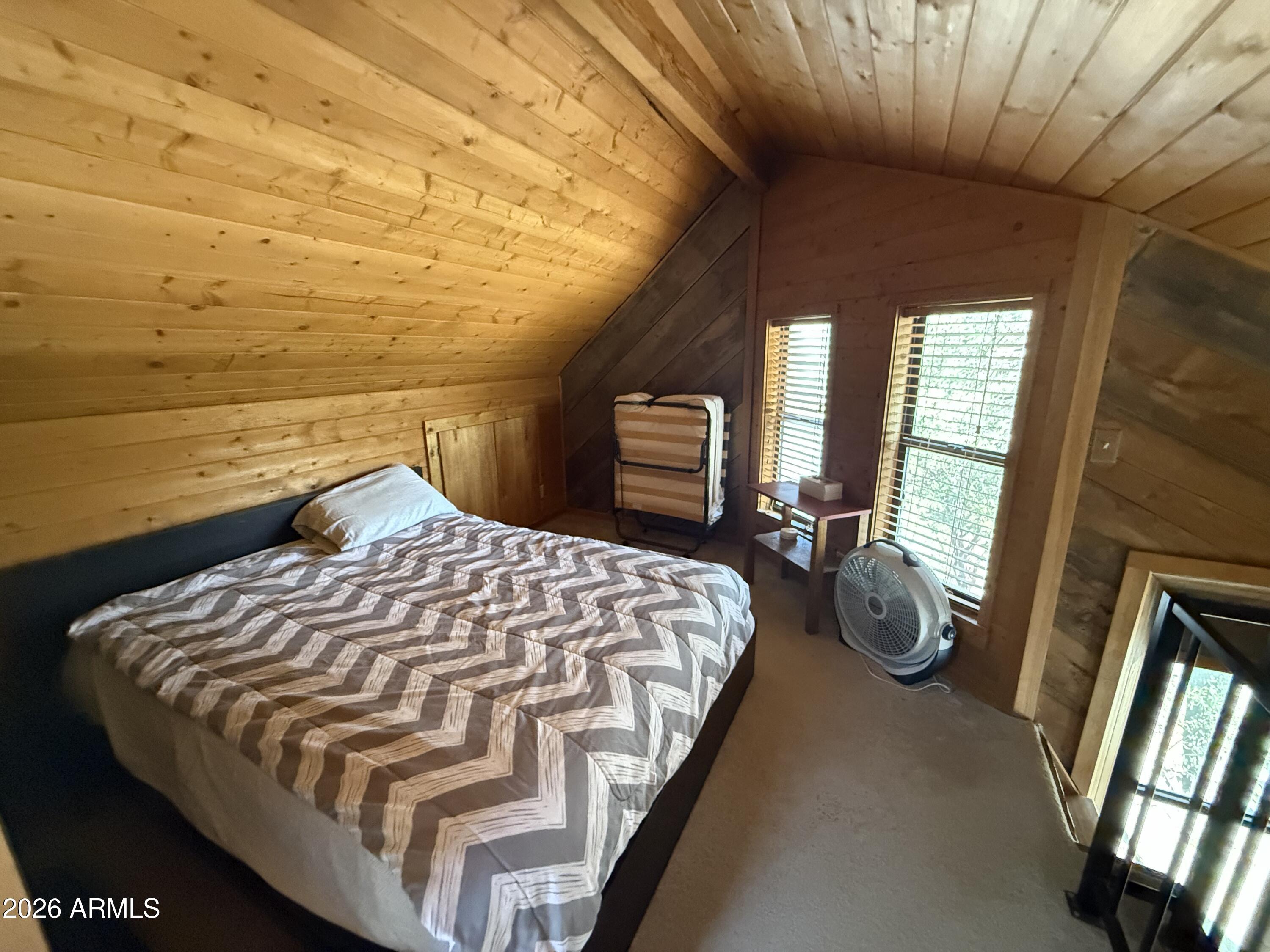 6687 Mountain View Road Crown King, AZ 86343 - Photo 14 of 18 a bed sitting in a bedroom next to a window