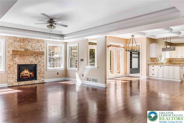 a view of a room with wooden floor chandeliers and kitchen