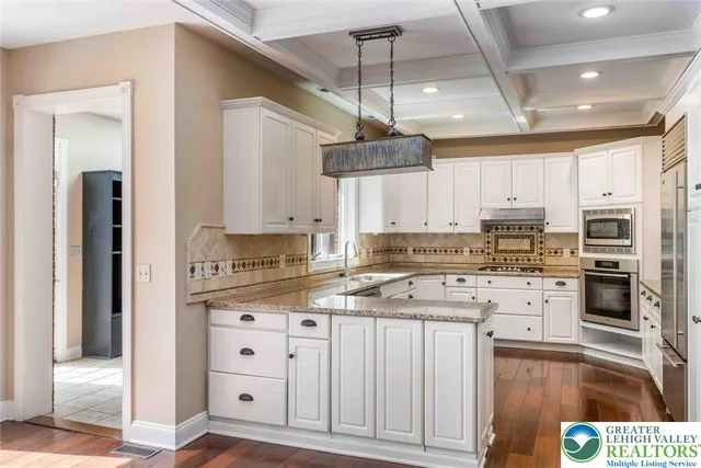 a kitchen with granite countertop white cabinets white stainless steel appliances and a sink