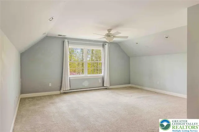 an empty room with a ceiling fan and a window