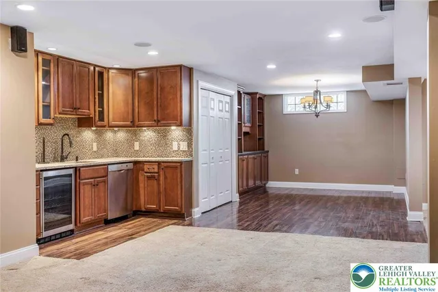 a view of an empty room with a fireplace and a kitchen