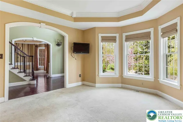 a large kitchen with stainless steel appliances granite countertop a stove a refrigerator a sink and white cabinets with wooden floor