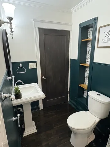 a bathroom with a toilet a sink and mirror