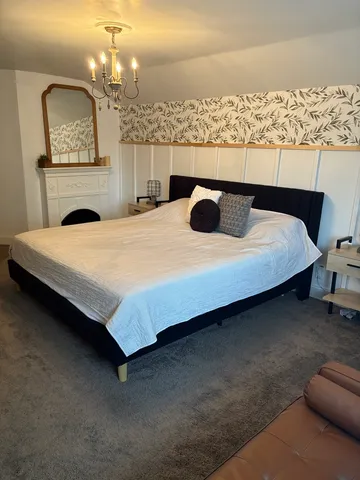 a bed sitting in a bedroom and chandelier