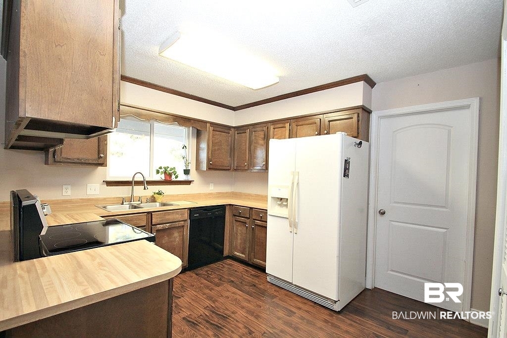 205 Montclair Loop Daphne, AL 36526 - Photo 3 of 19 Kitchen with black dishwasher, white fridge with ice dispenser, dark wood-type flooring, and sink