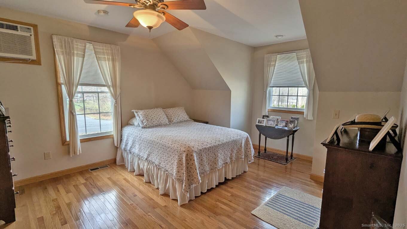 34 Hog Hill Road East Hampton, CT 06424 - Photo 6 of 11 a spacious bedroom with a bed a chandelier windows and wooden floor