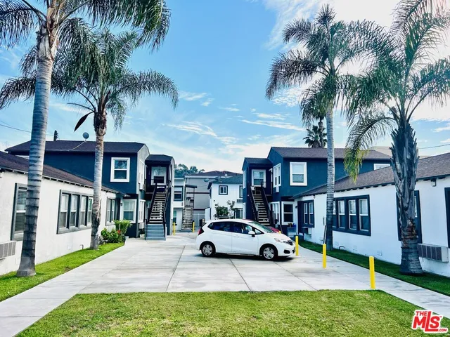 a car parked in front of a brick house with a large tree