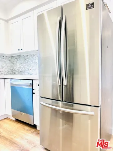 a view of a refrigerator in kitchen with stainless steel appliances granite countertop cabinets and a refrigerator