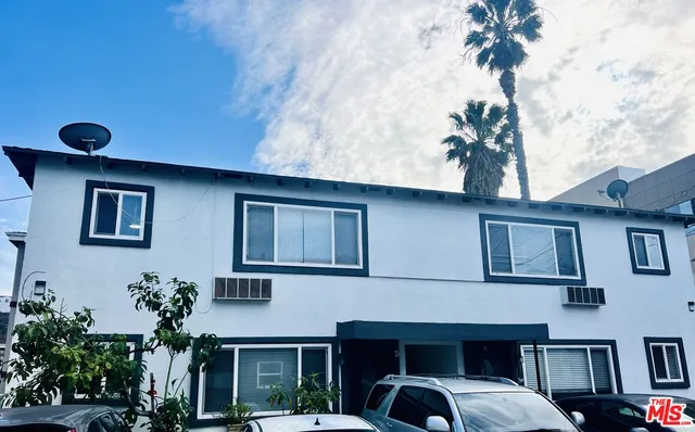 a front view of a house with plants