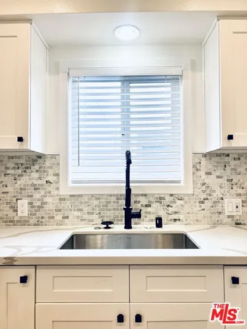 a kitchen with stainless steel appliances white cabinets and a window