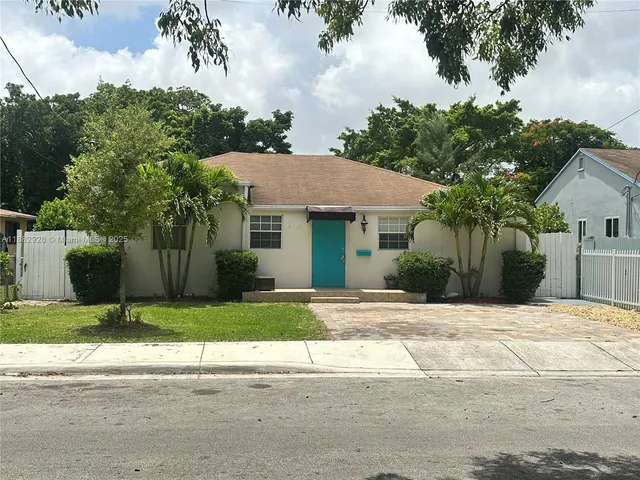 a front view of a house with a yard and trees