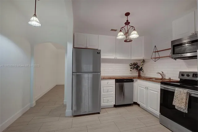 a kitchen with stainless steel appliances granite countertop a stove a refrigerator and a microwave