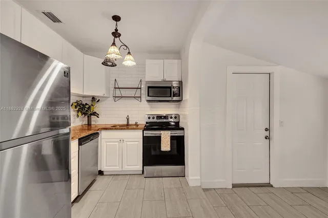 a kitchen with stainless steel appliances a refrigerator sink and cabinets