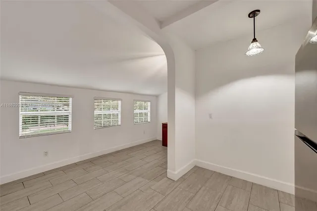 a view of an empty room with closet and a window