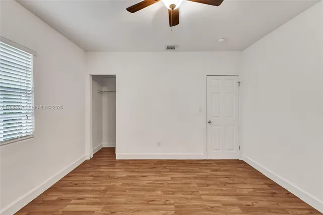 a view of a kitchen with wooden floor and a window