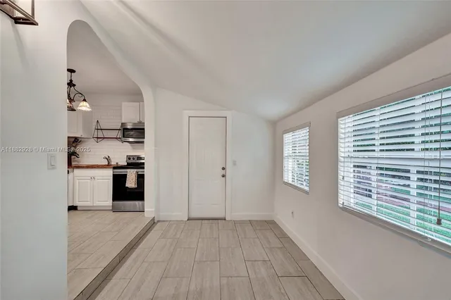 a view of a hallway with wooden floor and closet