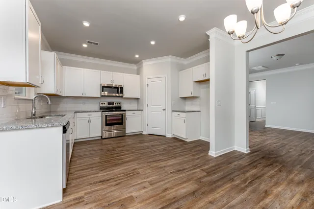 a kitchen with kitchen island granite countertop a refrigerator and a stove top oven