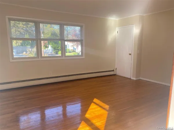 a view of a room with wooden floor and window