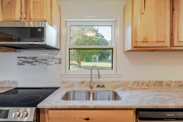 a kitchen with granite countertop a sink and a window