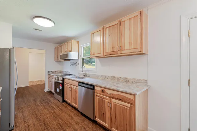 a kitchen with stainless steel appliances granite countertop a sink stove and refrigerator