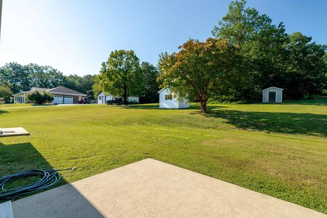 a view of a big yard with an ocean view