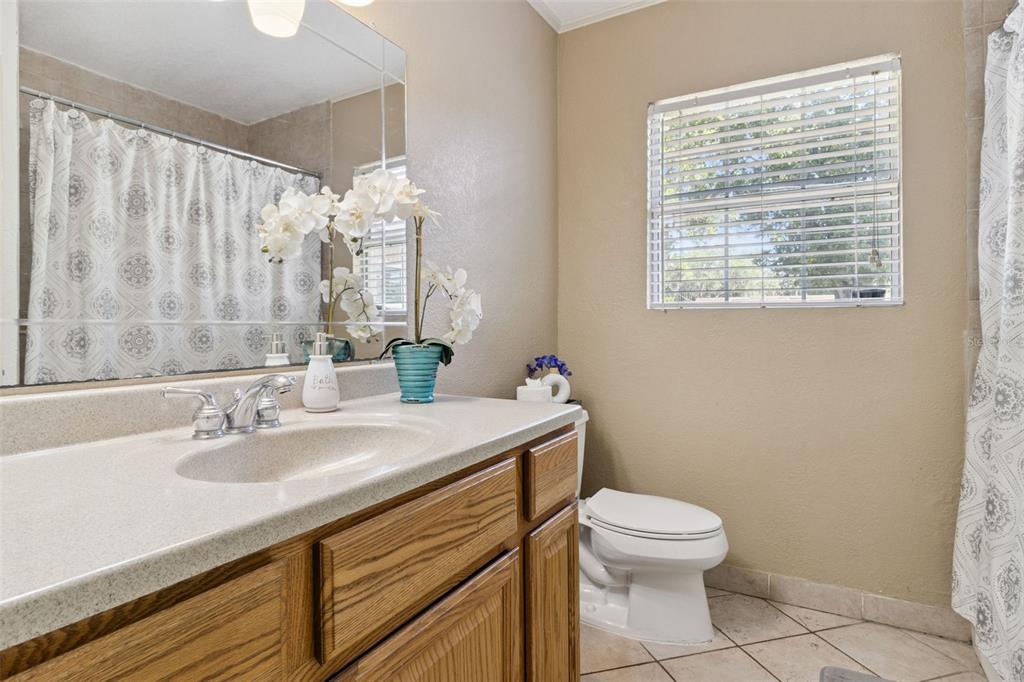 303 Granada Road Auburndale, FL 33823 - Photo 13 of 25 a bathroom with a sink a toilet and a mirror