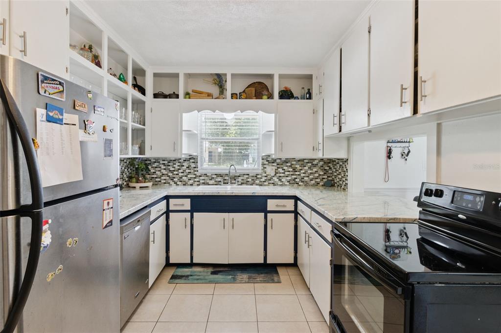 303 Granada Road Auburndale, FL 33823 - Photo 7 of 25 a kitchen with stainless steel appliances granite countertop a sink stove and cabinets