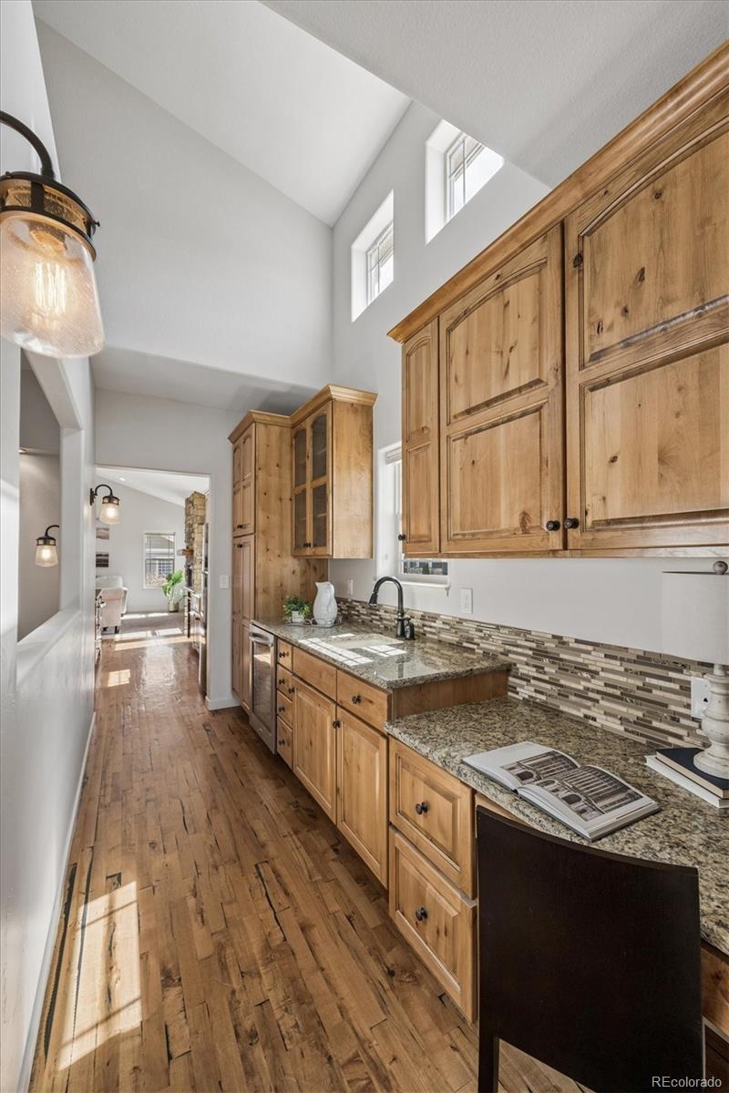 3674 Watts Street Timnath, CO 80547 - Photo 12 of 50 a large kitchen with stainless steel appliances granite countertop a stove a sink dishwasher and cabinets with wooden floor