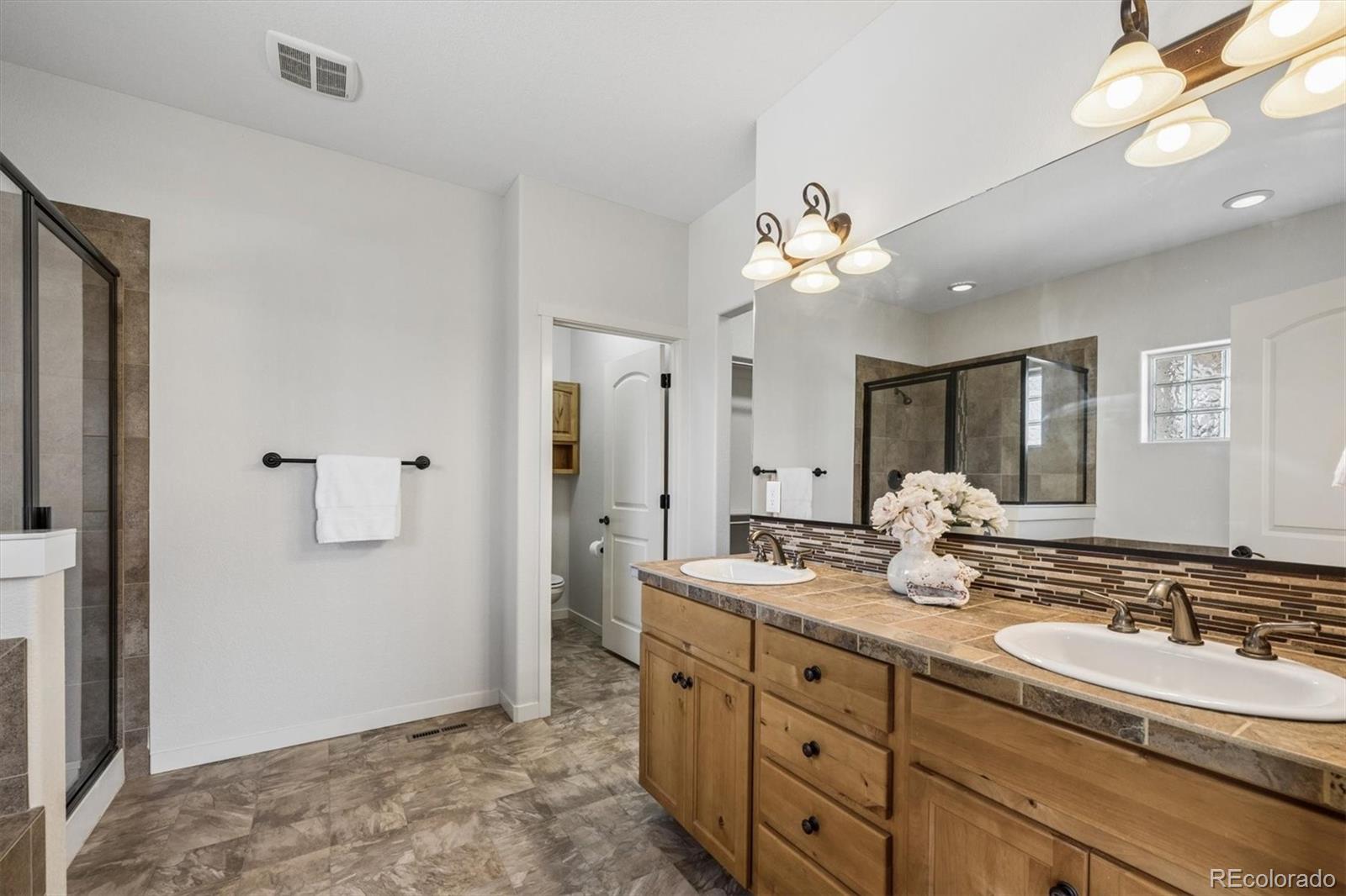 3674 Watts Street Timnath, CO 80547 - Photo 15 of 50 a bathroom with a double vanity sink and a mirror