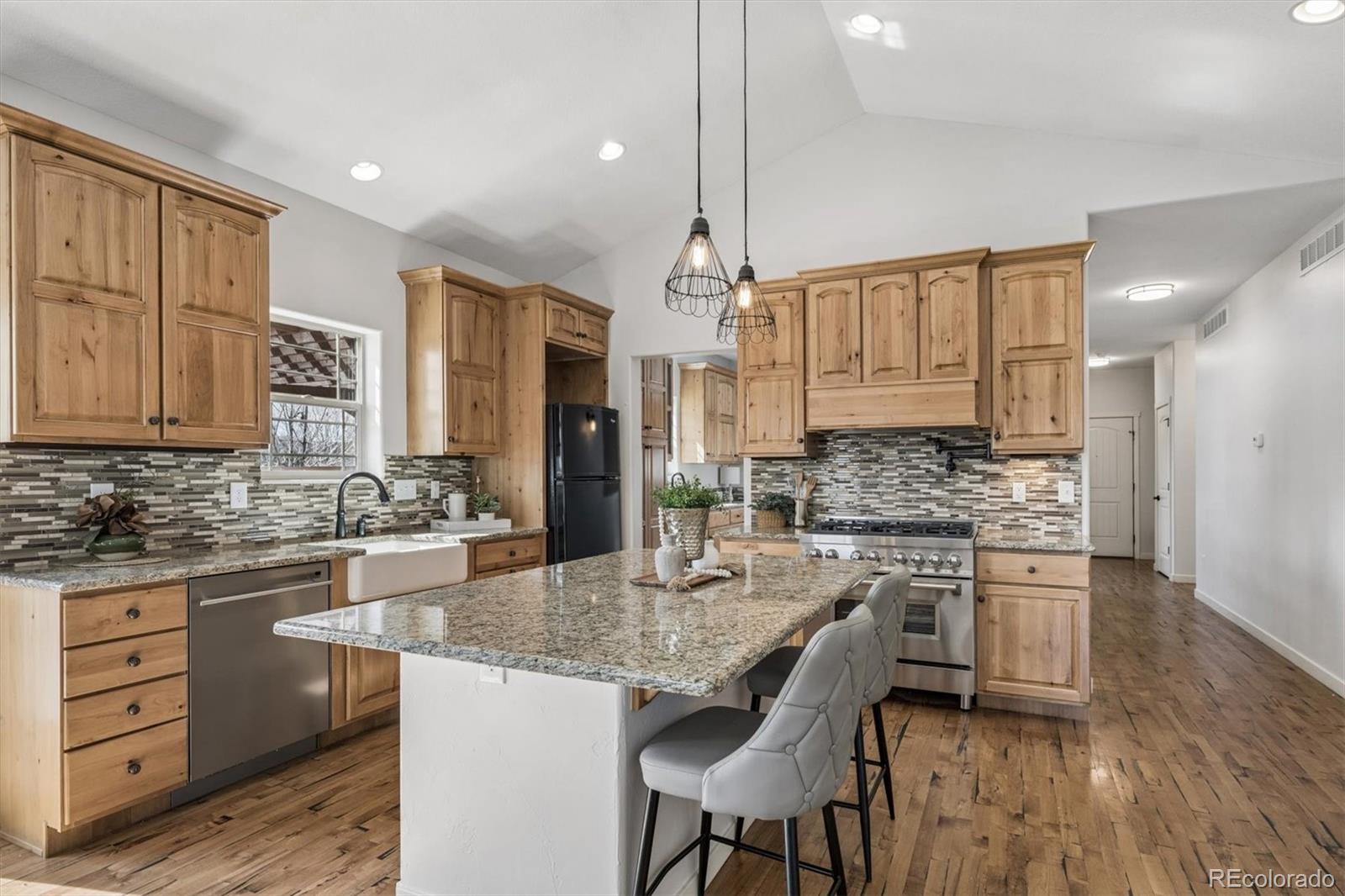 3674 Watts Street Timnath, CO 80547 - Photo 8 of 50 a kitchen with stainless steel appliances granite countertop a stove refrigerator and cabinets