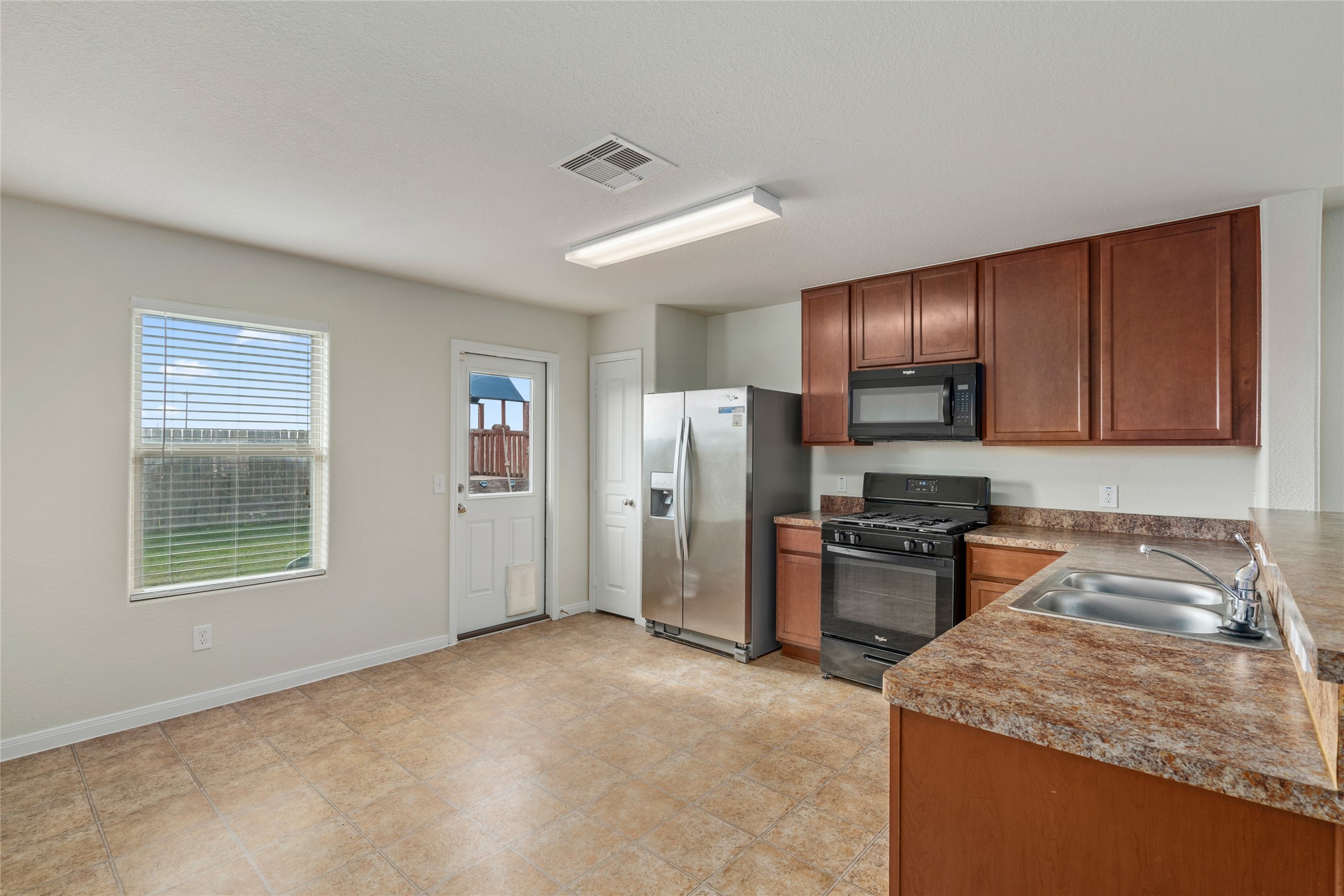 1323 Pease River Lane Rosenberg, TX 77471 - Photo 10 of 31 a kitchen with stainless steel appliances granite countertop a stove sink microwave and refrigerator