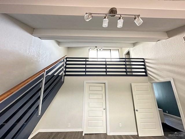 1512 Falcon Avenue McAllen, TX 78504 - Photo 13 of 14 Staircase featuring a textured wall, wood finished floors, beam ceiling, and a towering ceiling