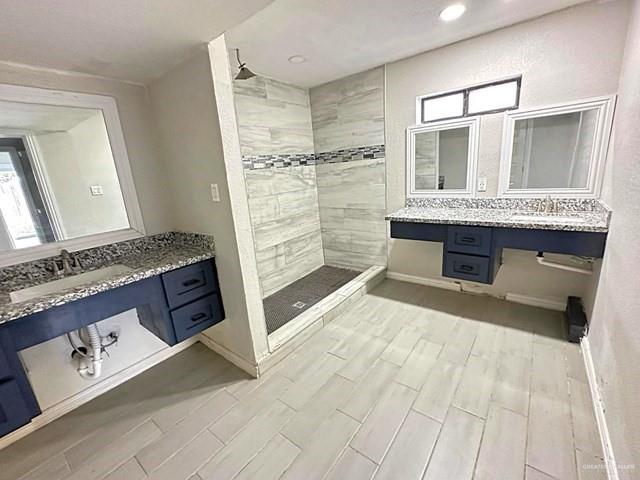 1512 Falcon Avenue McAllen, TX 78504 - Photo 10 of 14 Full bathroom featuring a stall shower, wood finish floors, and two vanities