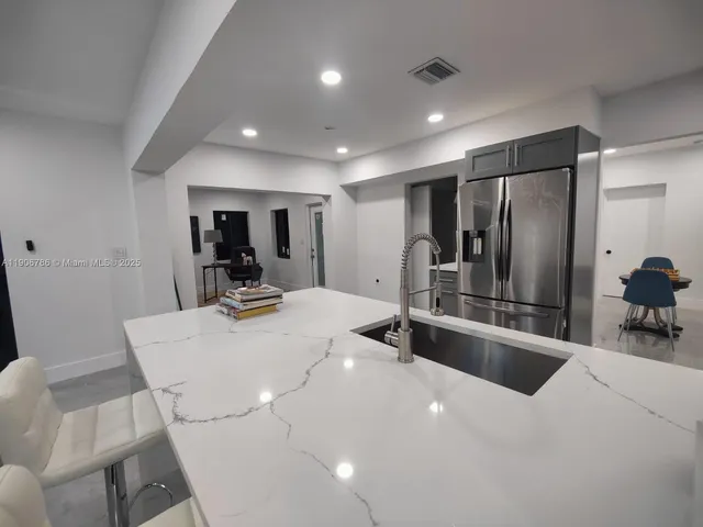 a kitchen with stainless steel appliances a sink and a refrigerator