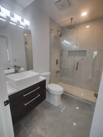 a bathroom with a toilet a sink and mirror