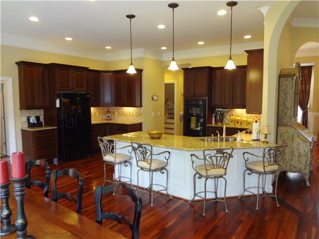 2059 Crescentview Road Pulaski, TN 38478 - Photo 6 of 20 a kitchen with stainless steel appliances granite countertop a refrigerator a stove a kitchen island and chairs with wooden floor