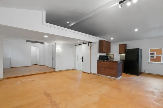 a large kitchen with stainless steel appliances granite countertop a refrigerator and a stove