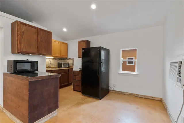 a kitchen with a refrigerator a stove top oven a sink and cabinets