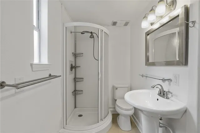 a bathroom with a toilet sink shower and mirror