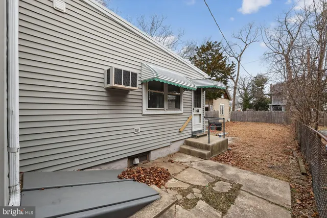a view of a white house with a small yard and large tree