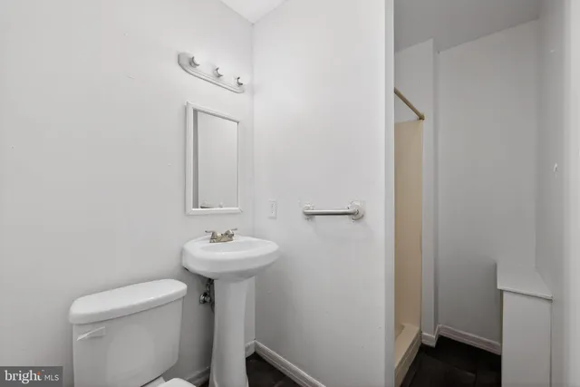 a bathroom with a sink toilet and a mirror
