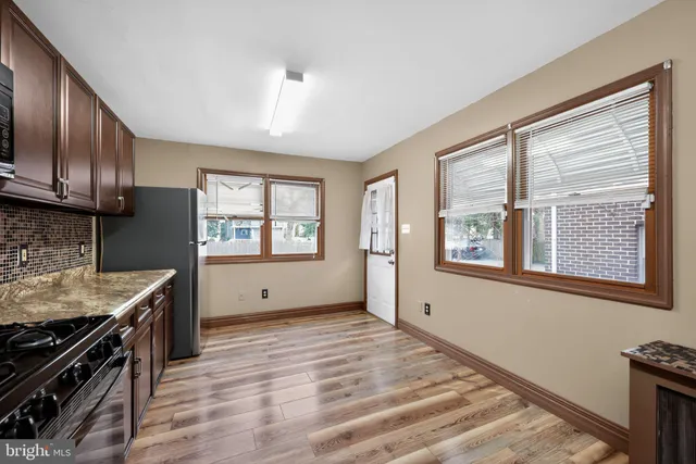 a view of a kitchen with an empty room wooden floor and a window
