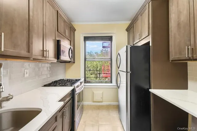 a kitchen with stainless steel appliances granite countertop a refrigerator a stove and a sink