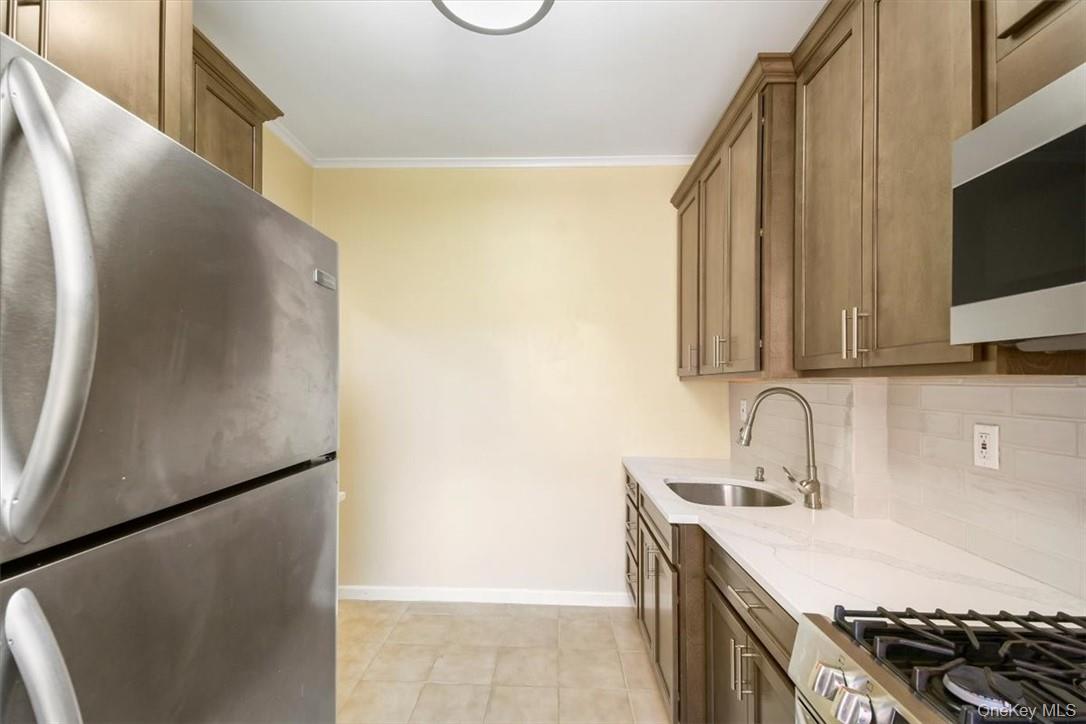 663 Locust Street, Unit 4A Mount Vernon, NY 10552 - Photo 21 of 31 a kitchen with stainless steel appliances granite countertop a sink stove and refrigerator