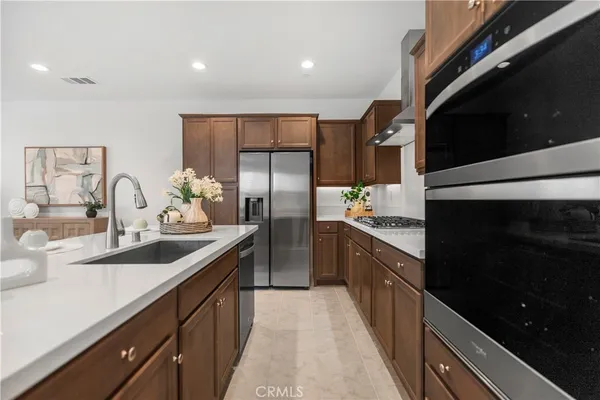 a kitchen with stainless steel appliances a sink stove and refrigerator