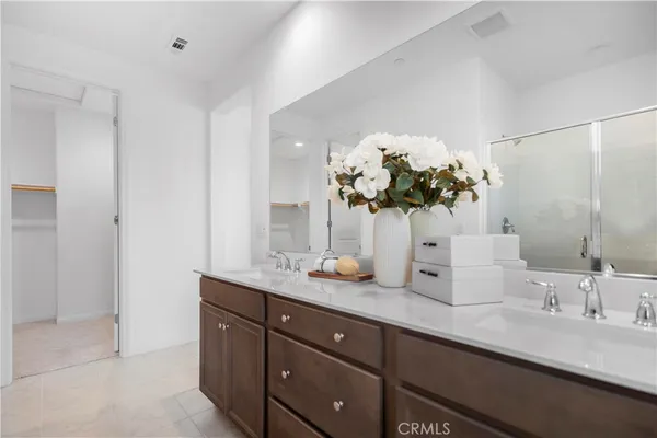 a bathroom with a granite countertop double vanity and a mirror