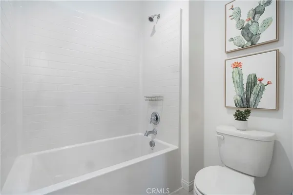 a white toilet sitting next to a bath tub