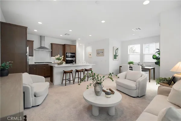 a living room with furniture a kitchen island a dining table and a couch